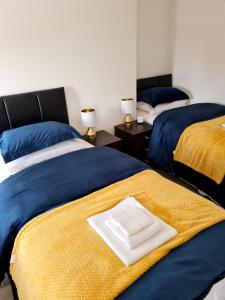 利物浦Family Home的蓝色和黄色的客房内的两张床