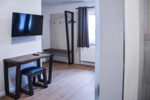 埃兴Hotel Pame Grill的小房间设有桌子和电视