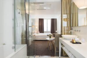 巴黎普拉西德圣日耳曼德普雷斯酒店的带淋浴、盥洗盆和浴缸的浴室