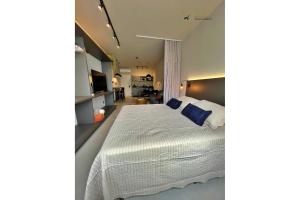 弗洛里亚诺波利斯Home Time Studios的卧室配有带蓝色枕头的大型白色床