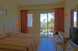 特里法Hotel Meninx Djerba的酒店客房设有两张床和电视。