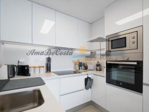 格兰阿利坎特CASCADA del MAR II - GRAN ALACANT的厨房配有白色橱柜和微波炉