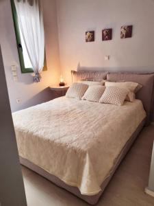 雅典City Break Metro Ambelokipi的卧室配有一张带白色床单的大床和窗户。