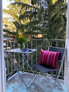 格拉茨奥斯达特豪斯城市公寓酒店的一张带粉红色枕头的椅子和一张桌子