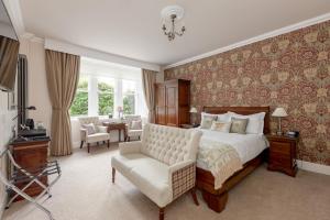 斯特灵Victoria Square & The Orangery的一间卧室配有一张特大号床和一把椅子