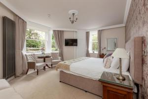 斯特灵Victoria Square & The Orangery的一间卧室配有一张床、一张桌子和一把椅子