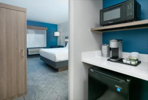 达拉斯Holiday Inn Express & Suites - Dallas Park Central Northeast, an IHG Hotel的酒店客房带一张床和一台微波炉