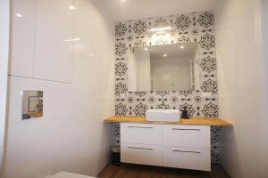 绿山城Drzewna Apartamenty -Augustowska的一间带水槽和镜子的浴室