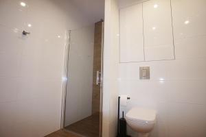 绿山城Drzewna Apartamenty -Augustowska的白色的浴室设有卫生间和淋浴。
