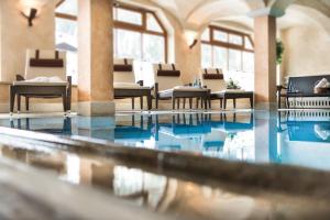 扎奥岑湖奥鹏霍夫高级酒店的大楼内带桌椅的游泳池
