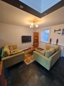 阿尔弗斯顿3 bedroom apartment in Ulverston Cumbria的客厅配有2张沙发和1台平面电视