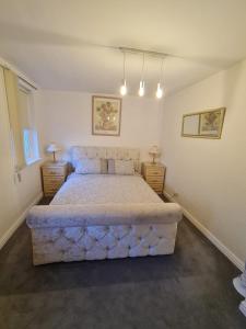 阿尔弗斯顿3 bedroom apartment in Ulverston Cumbria的一间卧室配有一张带2个床头柜的大床