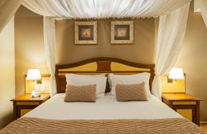 格拉玛多西拉角酒店的一间卧室配有一张大床、两个床头柜和两盏灯。
