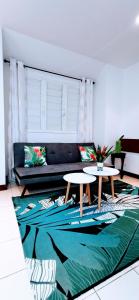 SarraméaEVASION Bungalow Tropical Spa的客厅配有两张桌子和一张沙发