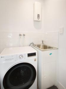 布里斯班Unit 3 - Manly Boutique Apartments的厨房配有洗衣机及水槽
