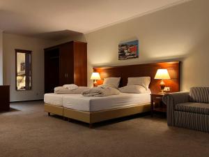 吕贝克Hotel Hanseatischer Hof的一间卧室配有一张大床和一张沙发