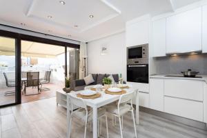 帕莱索海滩apartamento paradise luxury的厨房以及带白色桌椅的起居室。