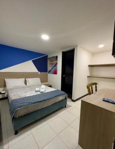 波哥大Hotel Santo Tomas Bogota的一间卧室设有一张床和蓝白色的墙壁