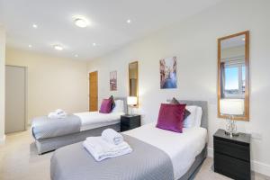 梅登黑德Spacious Luxury 3 Bed Apt W Parking by 360Stays的酒店客房,设有两张床和镜子