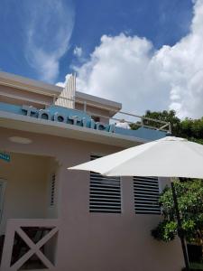 别克斯Casa de Tortuga Guesthouse的前面有白色雨伞的建筑
