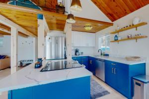 HoodsportAquamarine Dreams的蓝色和白色的厨房设有木制天花板