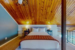 HoodsportAquamarine Dreams的一间卧室设有一张木天花板床。