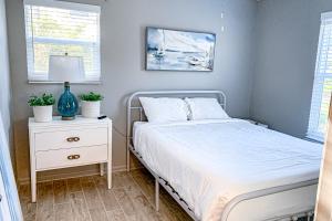 圣乔治岛Sea Pine Cottage的一间卧室配有一张床,床头柜配有一张白色的床