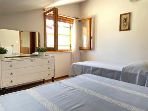 皮内托Una mansarda al mare的一间卧室配有两张床、一个梳妆台和镜子