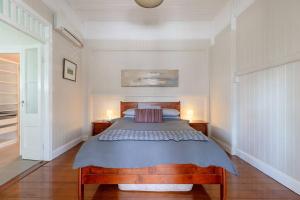 布里斯班Quaint & Cosy 1 Bedroom Apartment in Queenslander.的一间卧室配有一张大床和两盏灯