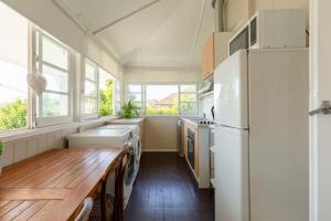 布里斯班Quaint & Cosy 1 Bedroom Apartment in Queenslander.的厨房配有冰箱和木桌
