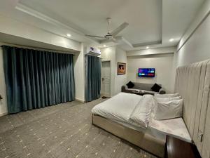 伊斯兰堡MUDAN hotel and suite的一间卧室配有一张大床和一张沙发
