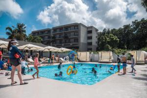 塔穆宁Hotel Tano Guam的一群人在游泳池玩耍