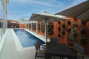 库利亚坎Culiacan Marriott Hotel的游泳池旁带遮阳伞的桌子
