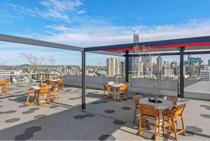 布里斯班New 3 Bed Penthouse Resort style complex的屋顶上带桌椅的天井