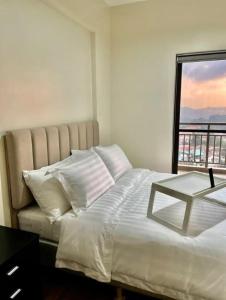 碧瑶One Suite at Bristle Ridge - Baguio City 2BR的卧室配有白色的床和窗户