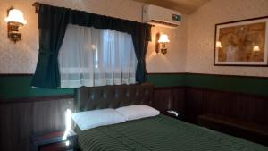 乌尼翁镇Tren Del Desierto的一间卧室设有一张绿色的床和一个窗户。