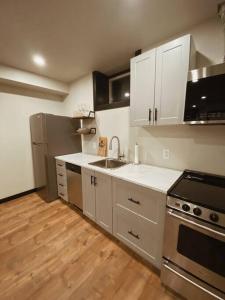 滑铁卢1-bedroom apartment in Uptown Waterloo的厨房配有白色橱柜和不锈钢用具