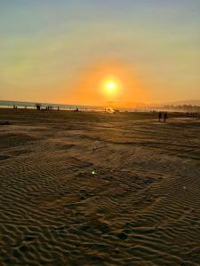 大普拉亚Pé na areia canto do forte II的海滩上的日落和海滩上的人