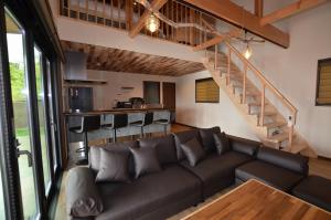 千葉地域ランキング1位獲得の贅沢な貸別荘全4棟的带沙发和楼梯的客厅