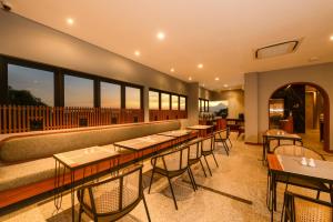 梭罗Nata Azana Hotel Solo的餐厅设有桌椅和窗户。