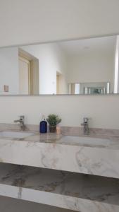 奥朱贝尔استراحة الضيافة的一间带三个水槽和大镜子的浴室