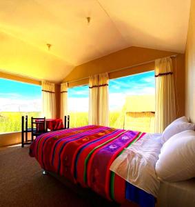 普诺Uros Maya Lodge的一间卧室设有一张床和一个大窗户