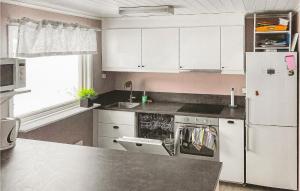 BråsstorpAmazing Home In Rottneros With Kitchen的厨房配有白色橱柜和白色冰箱。