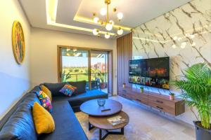 马拉喀什Cozy Golf Apartment Wifi 4k-TV Netflix的客厅配有蓝色的沙发和电视