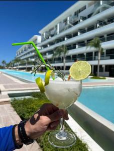 蓬塔卡纳Cana Rock Star luxury condo, Casino, golf, beach in Hard Rock área的池前喝着饮料的人