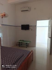 隆海Nhà nghỉ Thiên Thanh 1的卧室配有一张床,墙上配有电视。