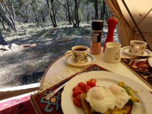 马其顿Macedon Ranges Glamping的桌上的鸡蛋和西红柿等食物