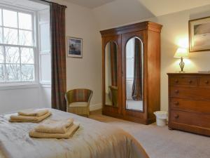 Kilmartin法克托乡村别墅的一间卧室配有一张床、梳妆台和镜子