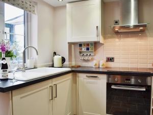 MatfieldDairy Cottage的厨房配有白色橱柜、水槽和窗户。
