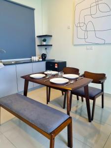 马六甲StaySuites The Apple Melaka的一间带桌子和两把椅子的用餐室